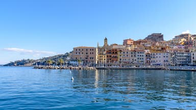 A coastal town with colorful buildings, a clear blue sky, and calm water.