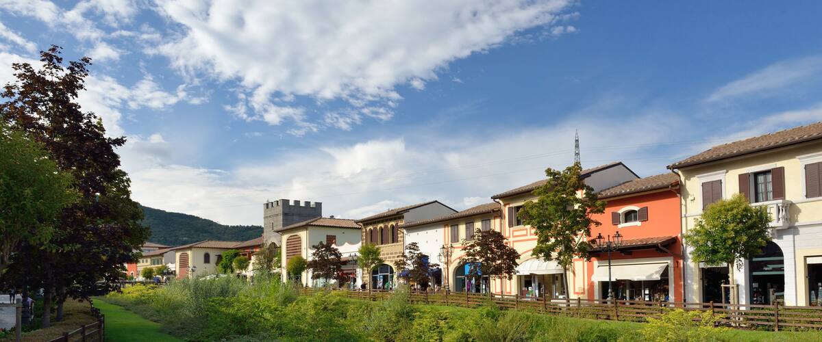 A quaint village with historic buildings, a castle, and lush greenery.