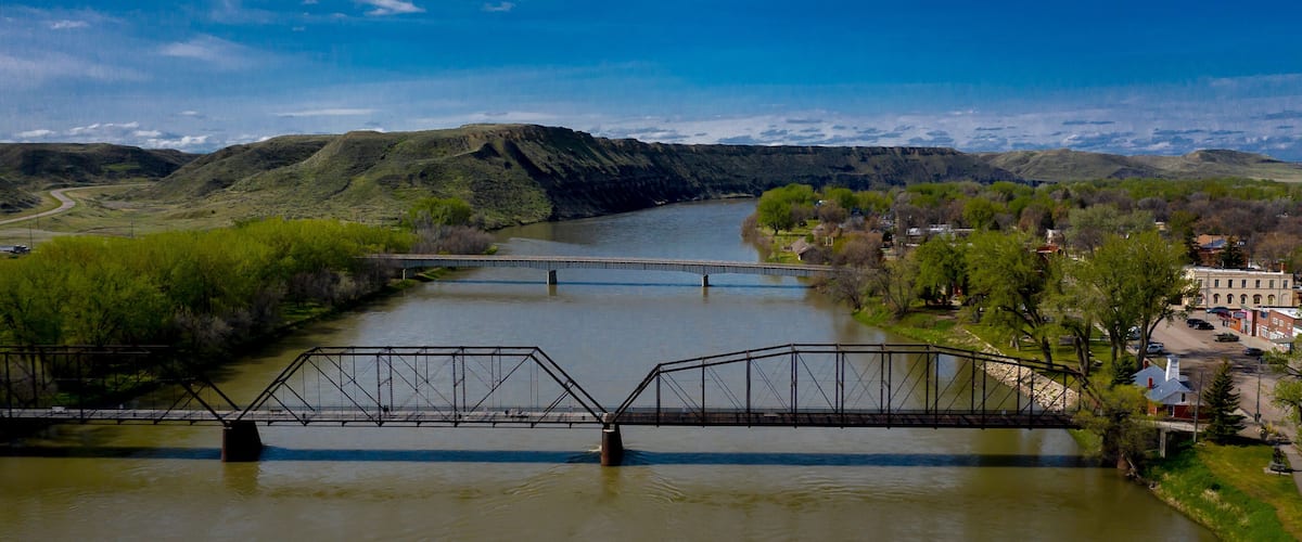 A river with a bridge, hills, and a town.