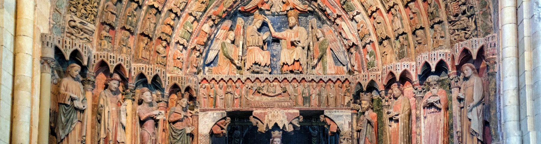 An ornate Gothic cathedral interior with detailed stone carvings and a large arched doorway.