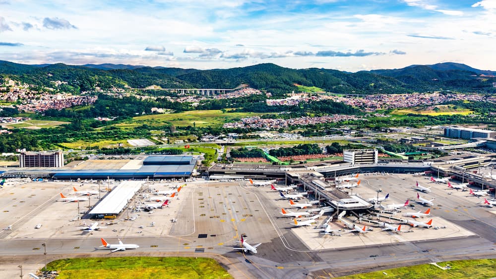 An airport surrounded by mountains and a town.