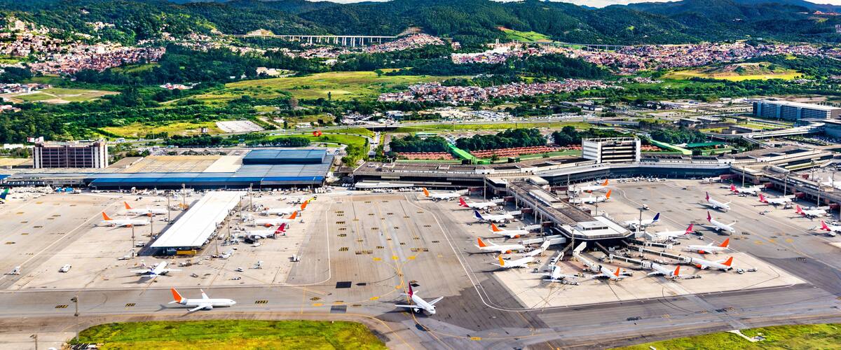 An airport surrounded by mountains and a town.