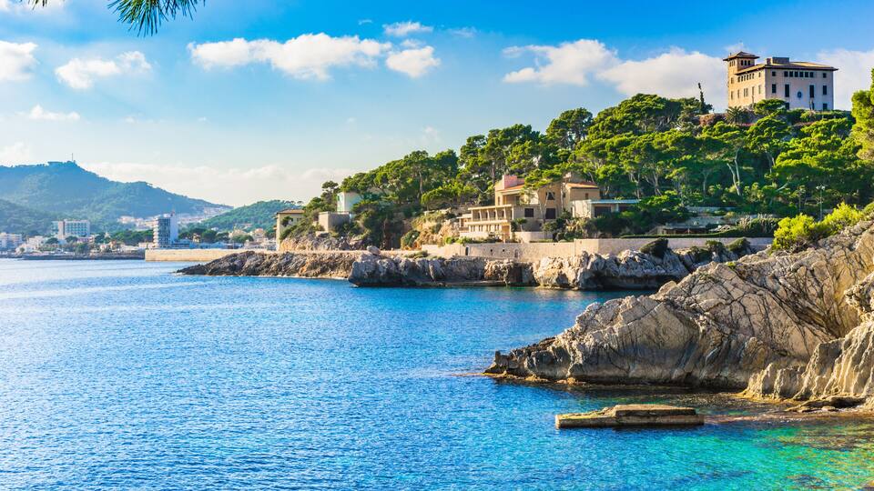 A coastal town with buildings on a hillside overlooking the sea.