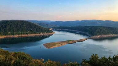 A river winding through a valley with forested hills.