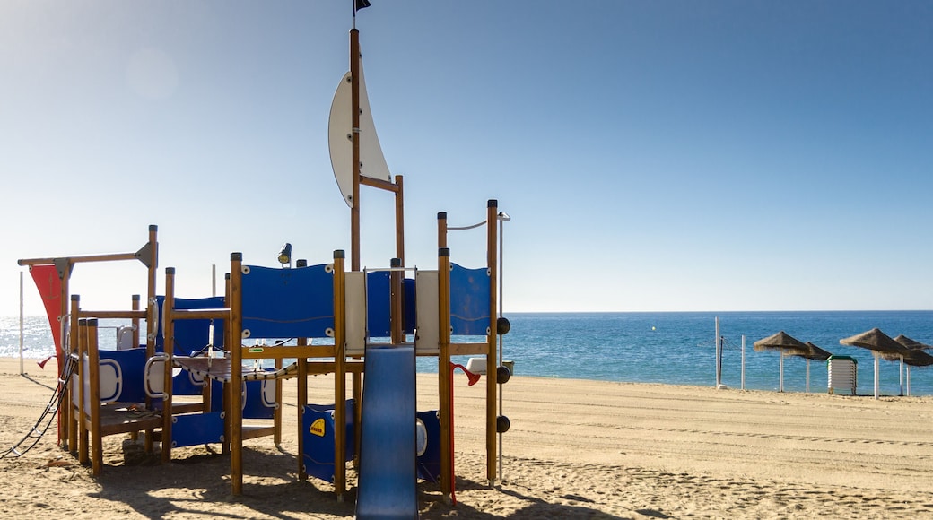 Playground on the sandy beach Spain. Mediterranean coast. Beautiful weather clear blue sky. Fun for children with parents on the beach. Always ready for tourists.