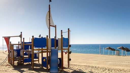 Playground on the sandy beach Spain. Mediterranean coast. Beautiful weather clear blue sky. Fun for children with parents on the beach. Always ready for tourists.