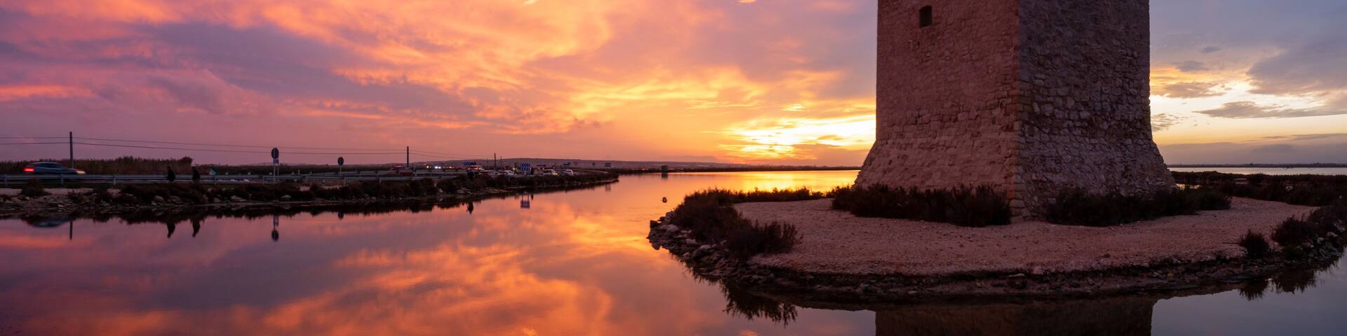 Sunset at Tamarit Tower (built in 16th century) and salt lagoons in Santa Pola, Alicante, Spain
