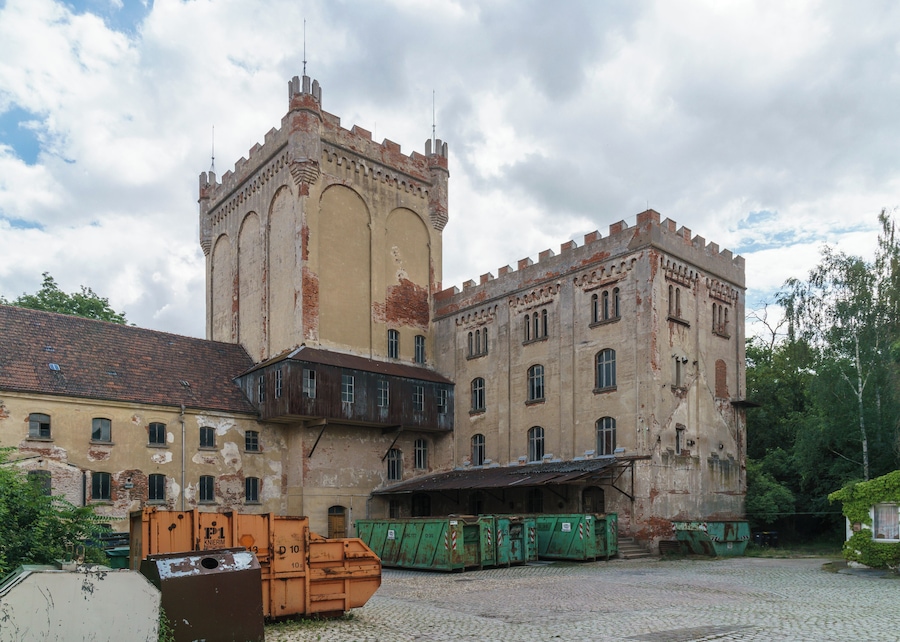 Ein altes, verwittertes Gebäude mit einem Turm und Rundbogenfenstern.