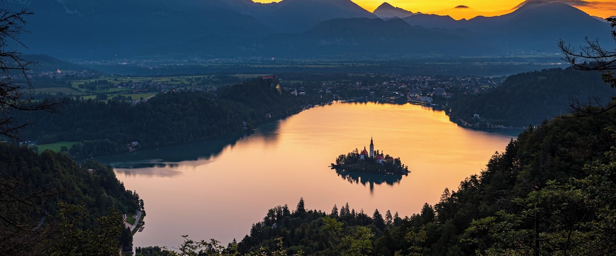 A lake surrounded by mountains at sunset.