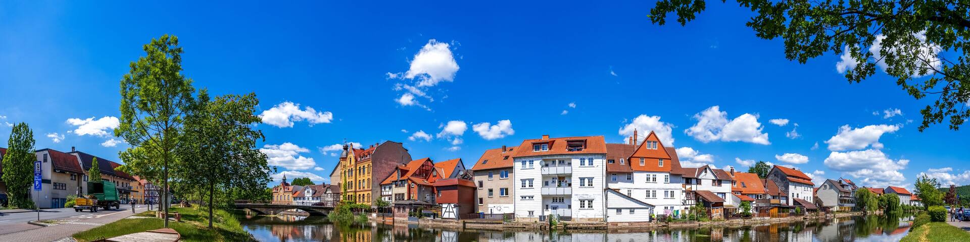 A river reflecting buildings, a bridge, and a duck.