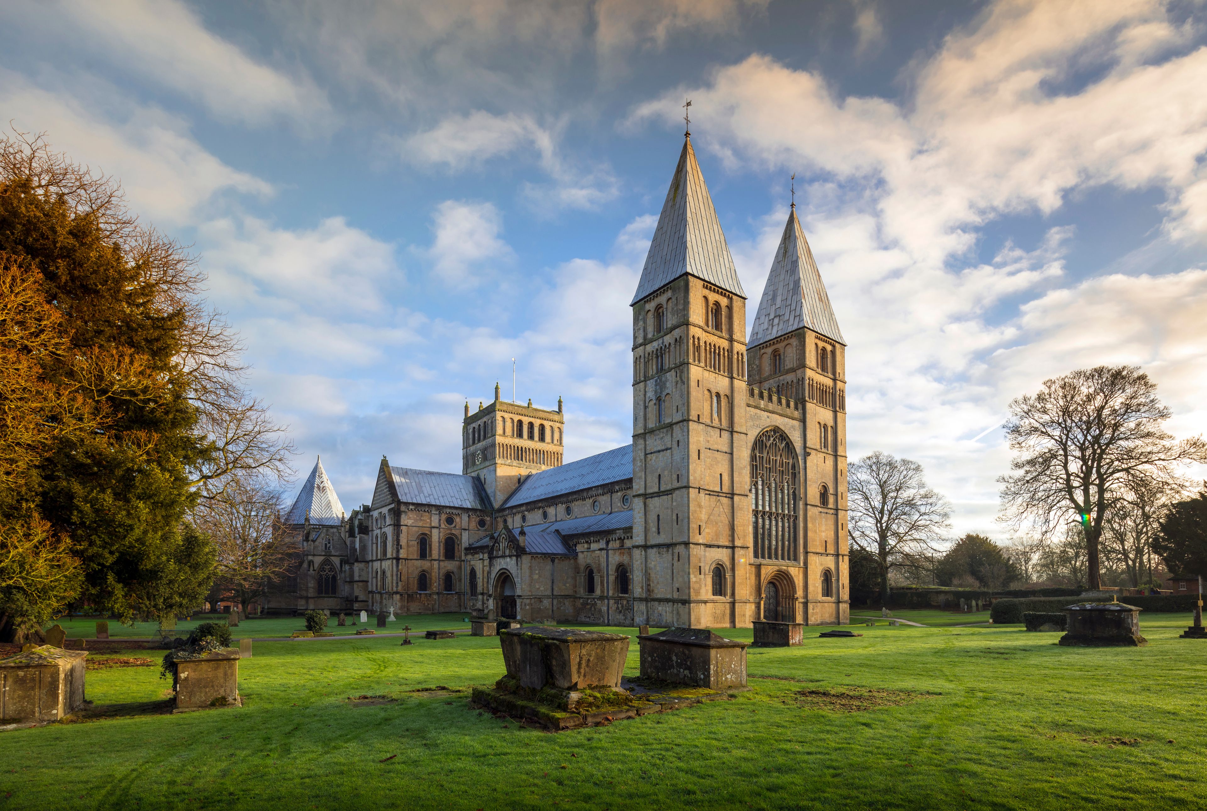 A historic church with two prominent towers and a well-maintained lawn.