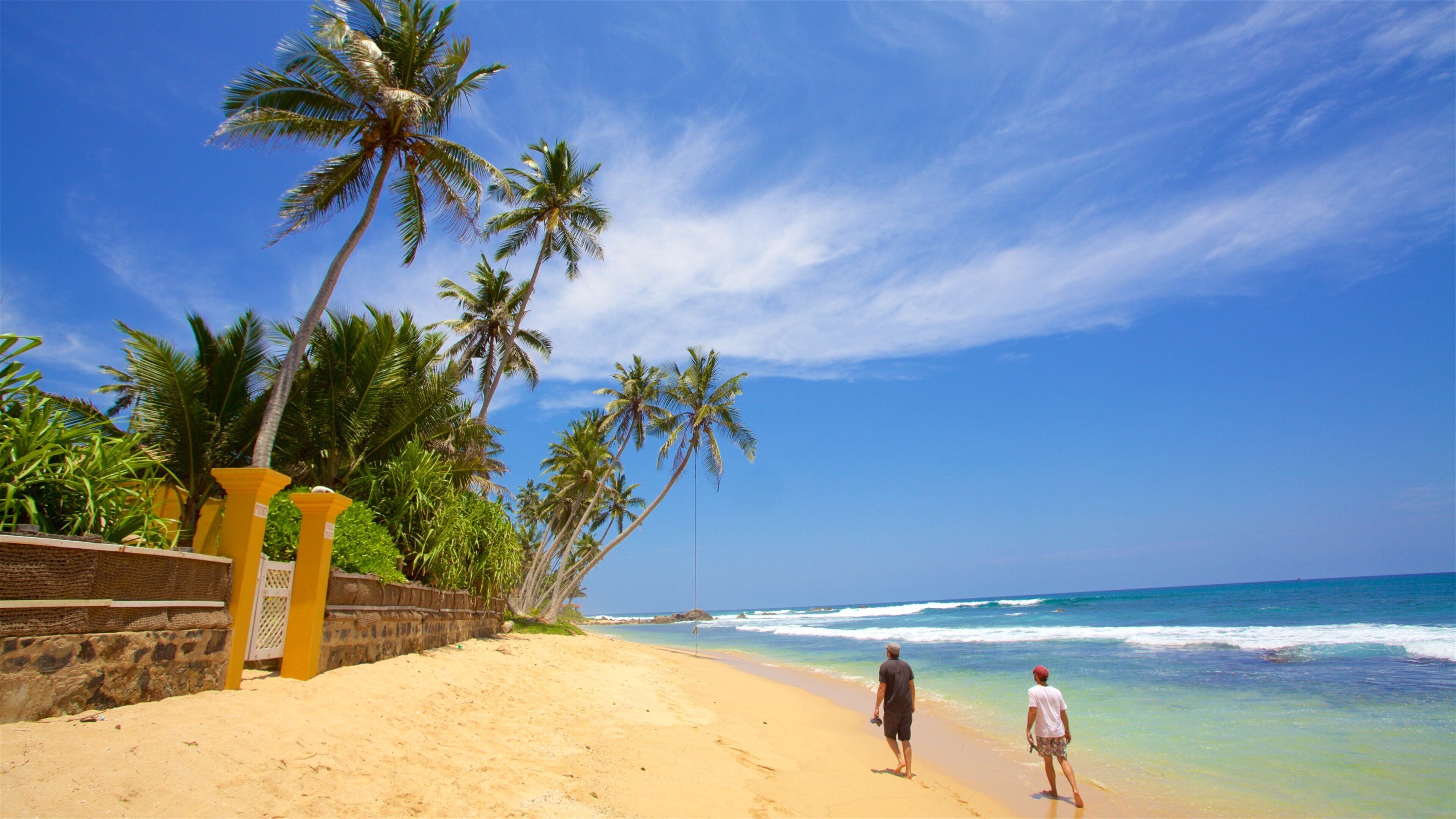 Galle featuring a sandy beach and tropical scenes as well as a small group of people