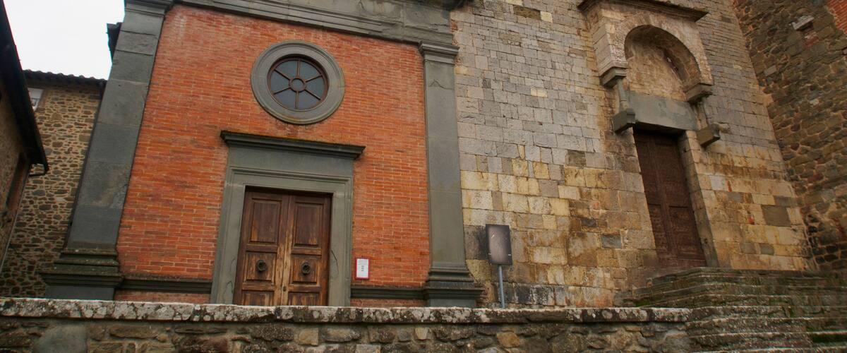 A historic church with a prominent clock tower, arched windows, and a stone facade.