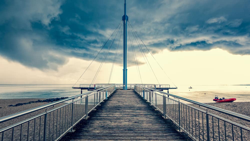 Sea bridge "Hohwachter Flunder" in Hohwacht, Baltic Sea, Schleswig-Holstein on overcast, storm sky Background in summer. Dramatic thunderstorm clouds over the Ocean