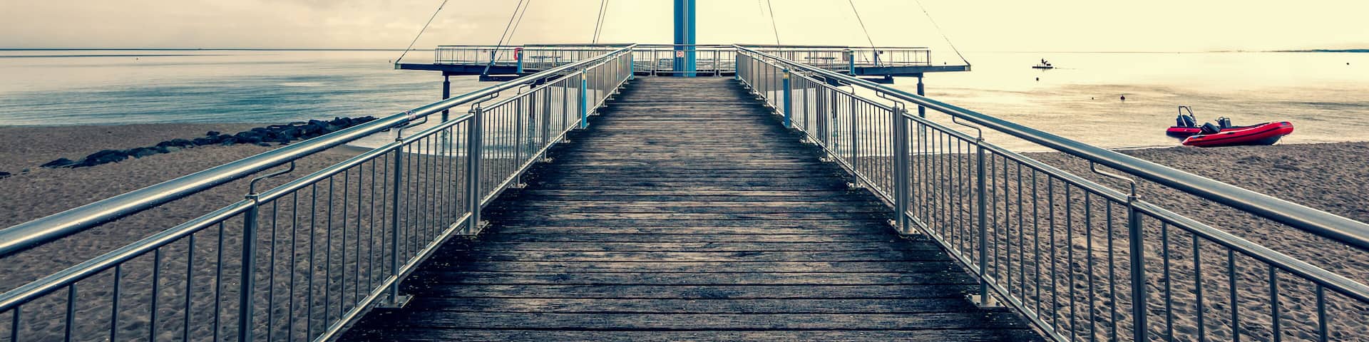 Sea bridge "Hohwachter Flunder" in Hohwacht, Baltic Sea, Schleswig-Holstein on overcast, storm sky Background in summer. Dramatic thunderstorm clouds over the Ocean