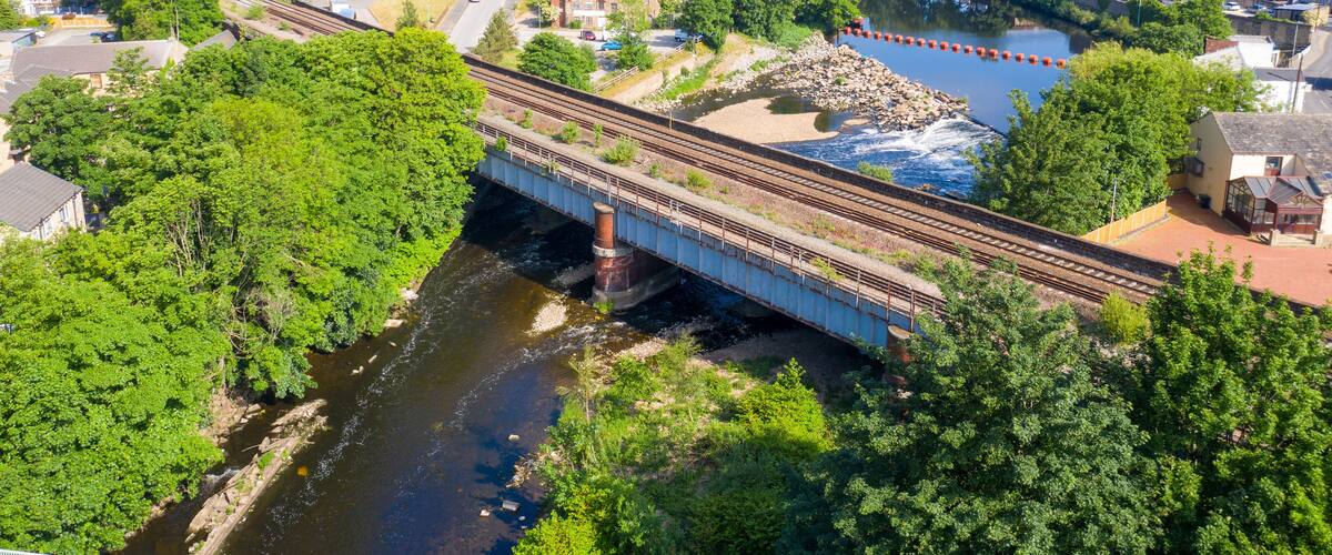 A bridge over a river with a town in the background.