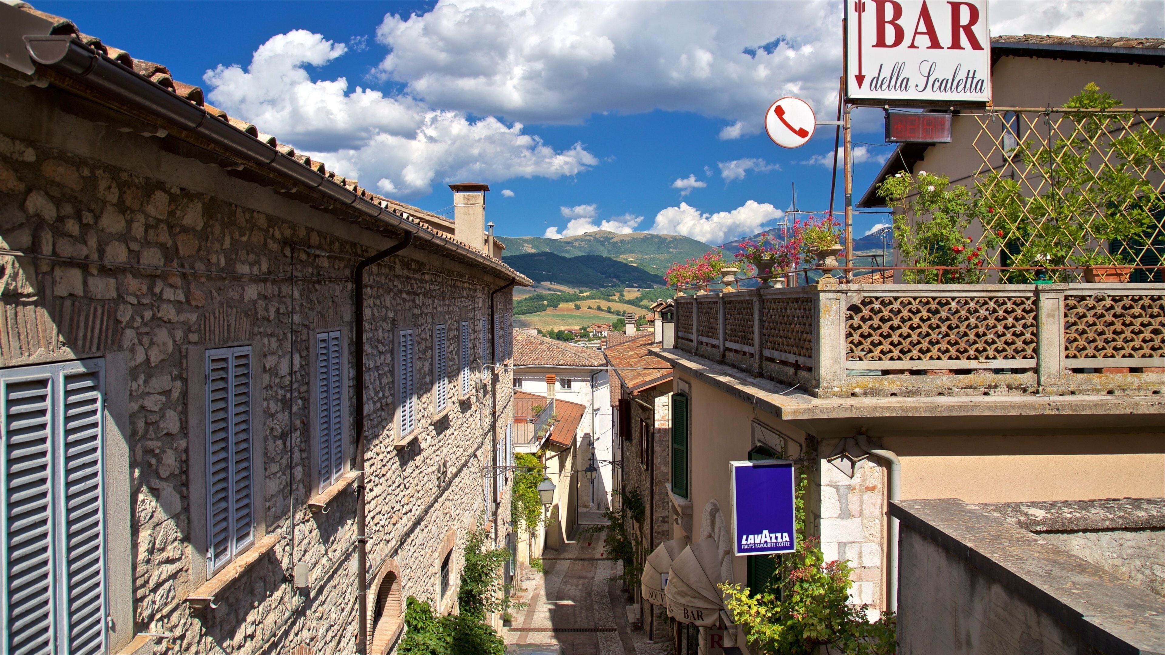 Cascia which includes signage, flowers and a small town or village