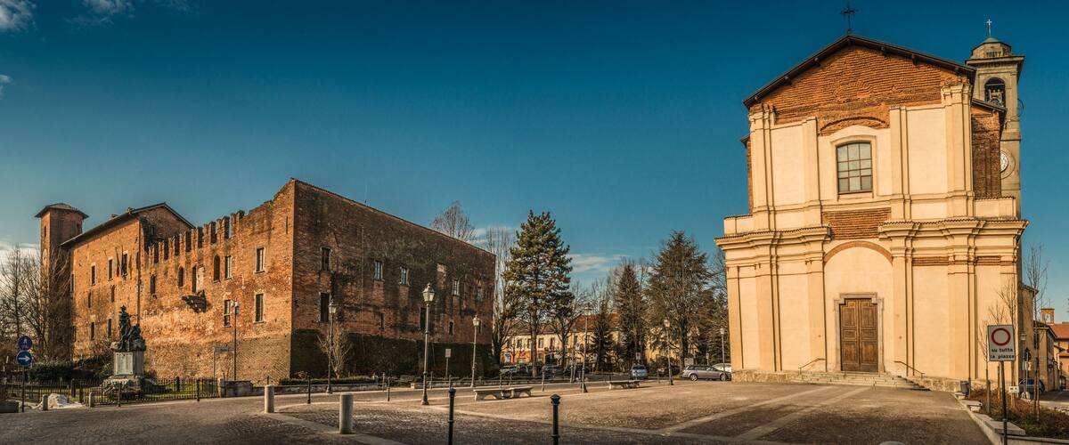 A historic building with a clock tower and a large brick structure.