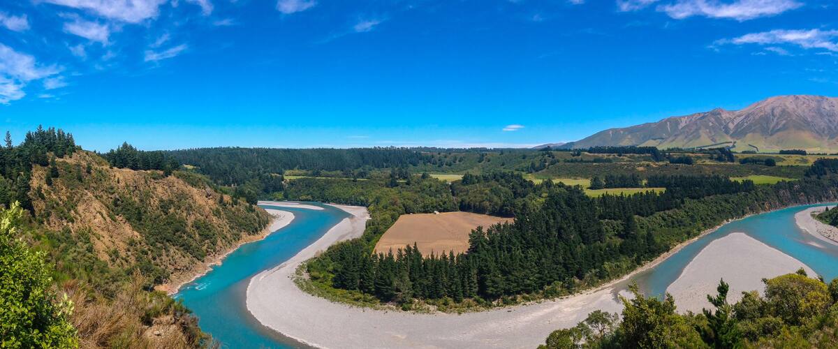 A river winding through a valley with a mountain in the background.