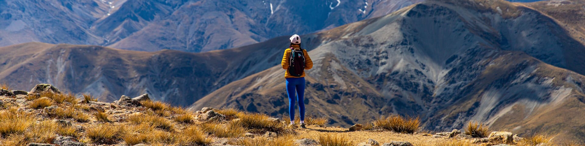 backpacker enjoying the stunning panorama of new zealand alps from the top of mount somers in canterbury