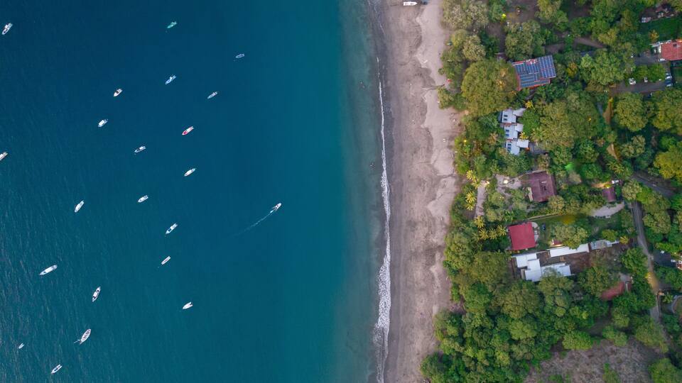 A coastal area with boats on the water and houses near the shore.