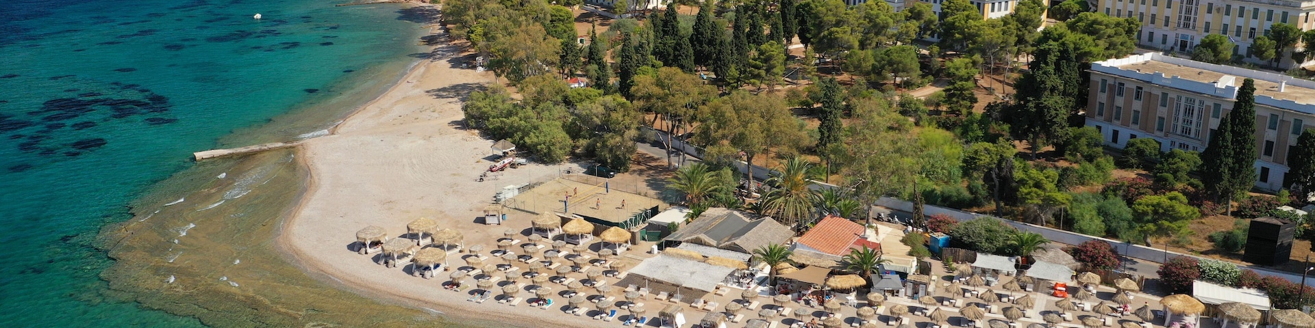 Un pueblo costero con playa, aguas turquesas cristalinas y una combinación de edificios residenciales y comerciales.
