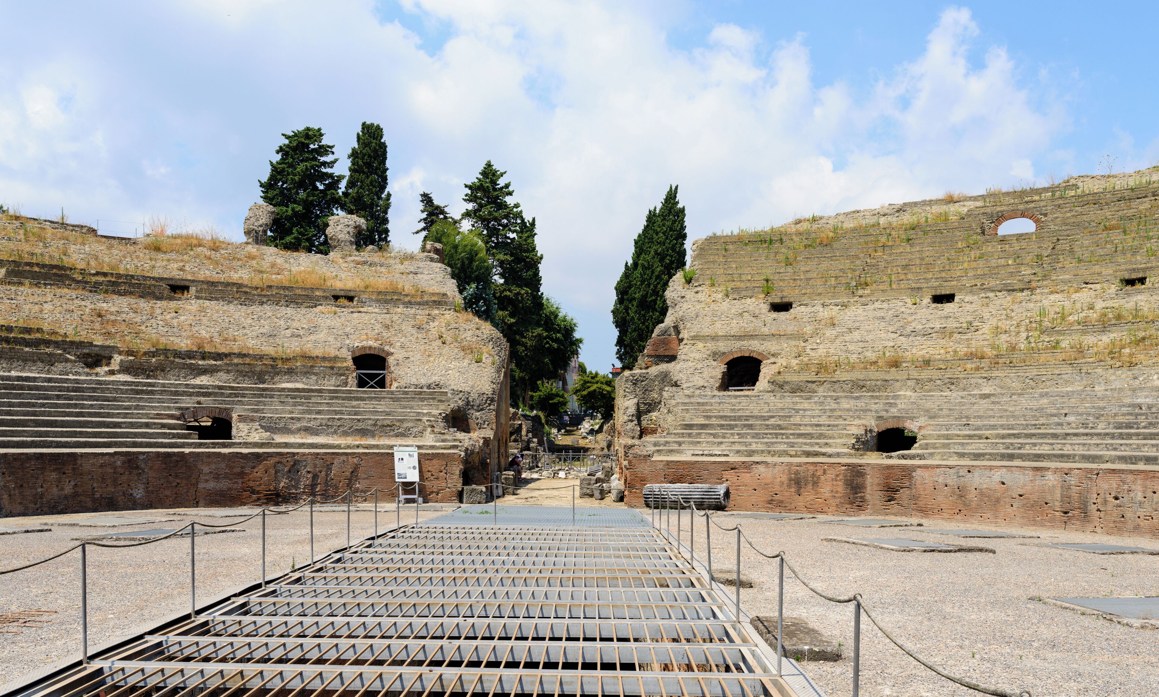 An ancient amphitheater with tiered seating and stone structures.