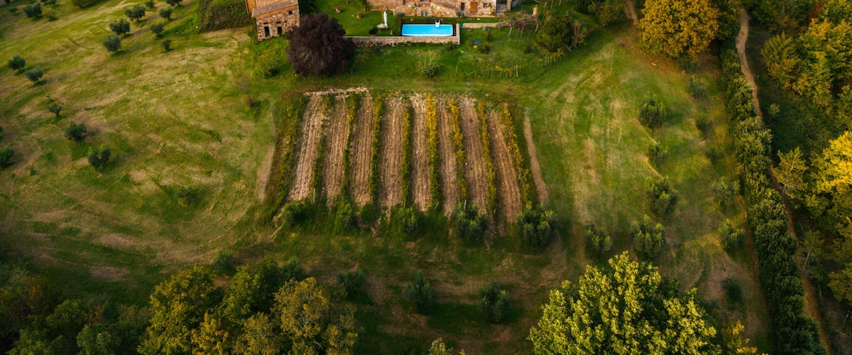 An aerial view of a historic stone church surrounded by lush greenery and terraced fields.