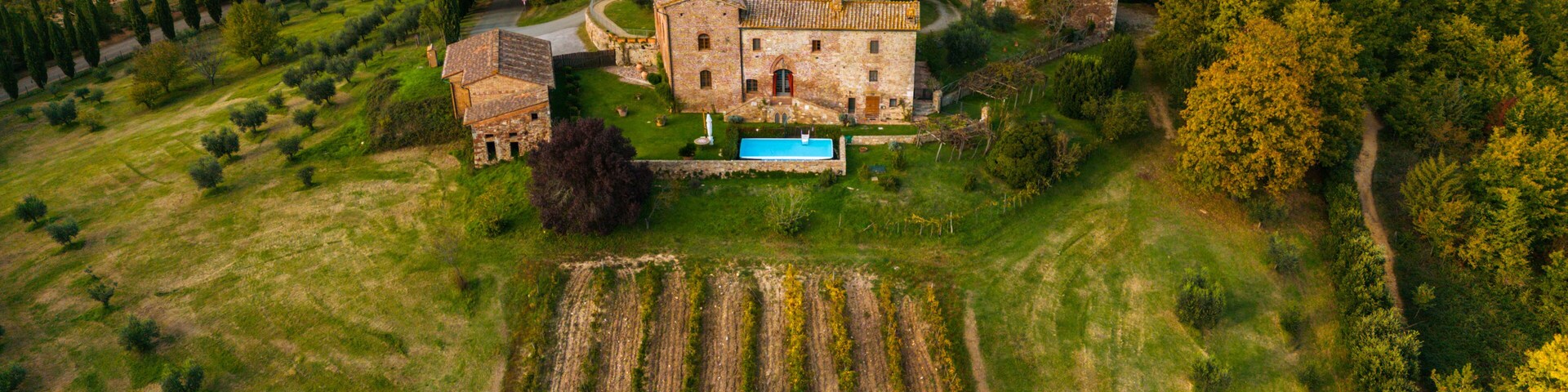 Vista aérea de una iglesia histórica de piedra rodeada de vegetación exuberante y campos en terrazas.