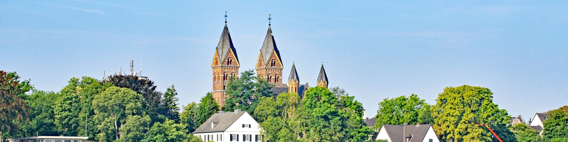 A river with a castle and several houses in the background.