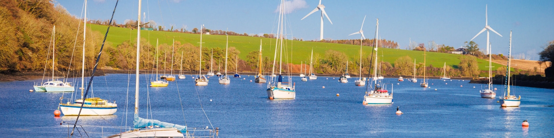 boats in the harbor with windmills in the background