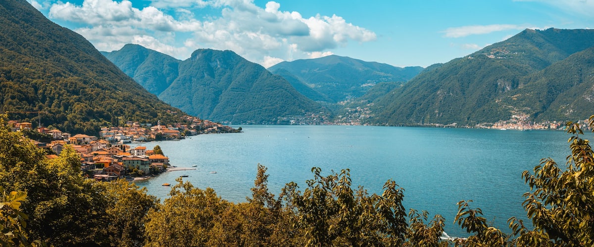 A lake surrounded by mountains with a town on the left.