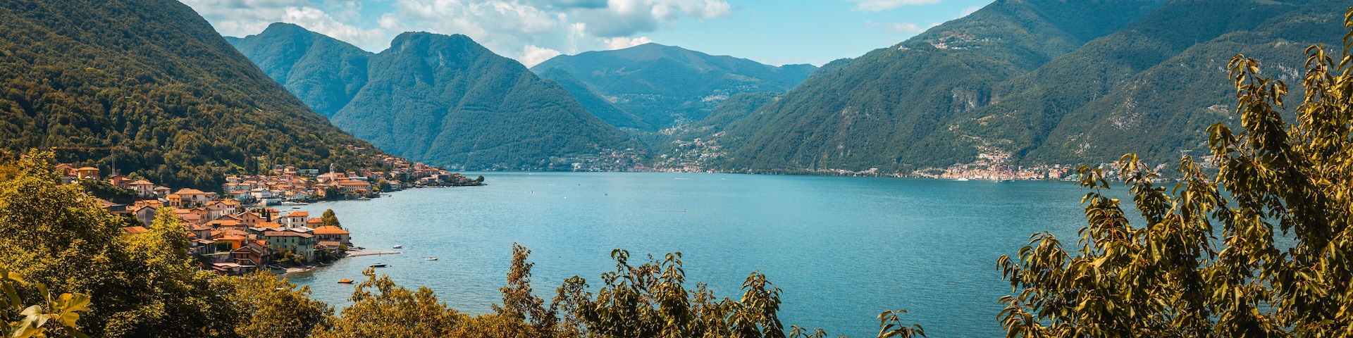 A lake surrounded by mountains with a town on the left.