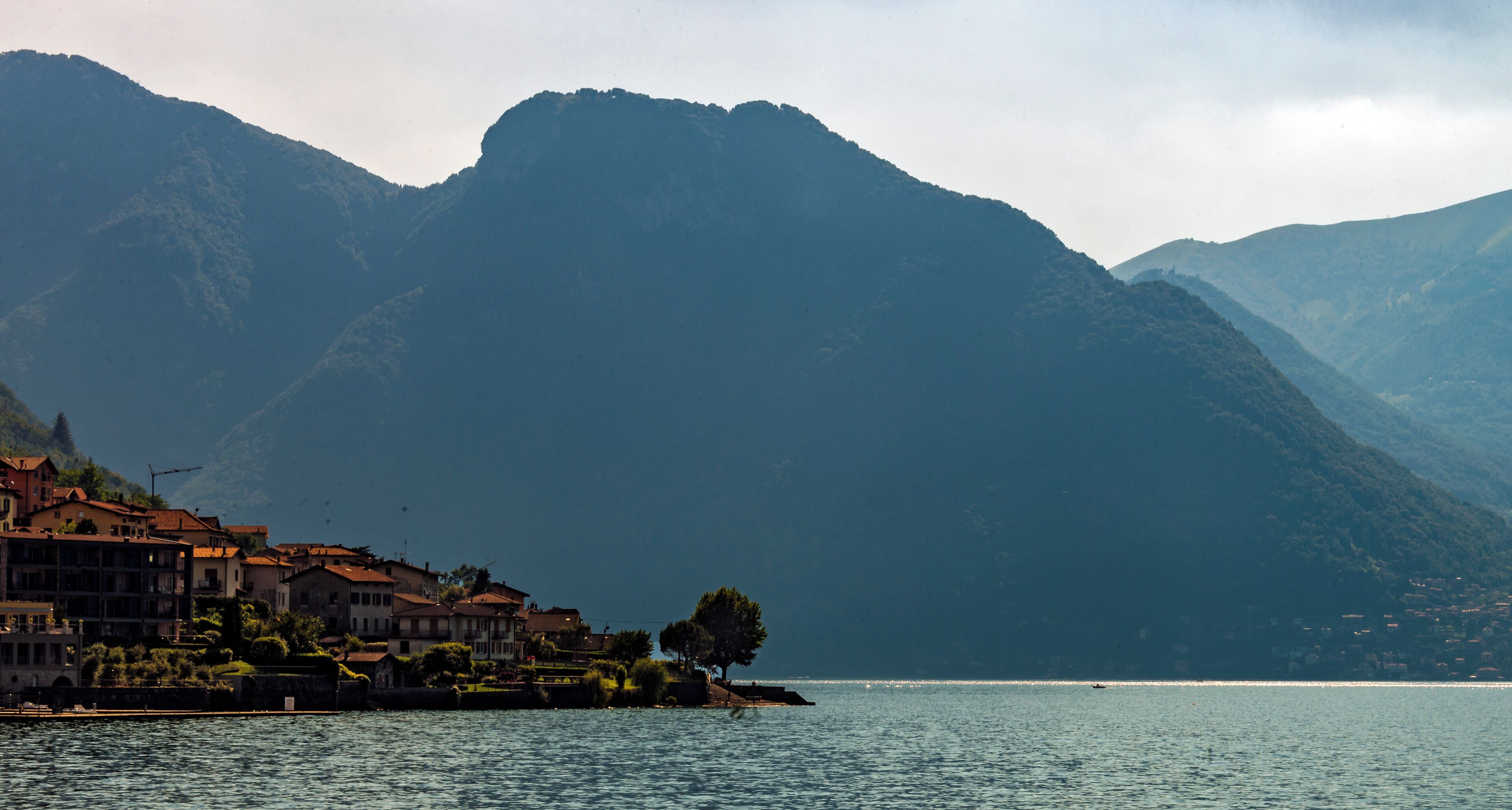 A promontory seen from the side as the Lake Como ferry pulls into the dock at Lezzeno