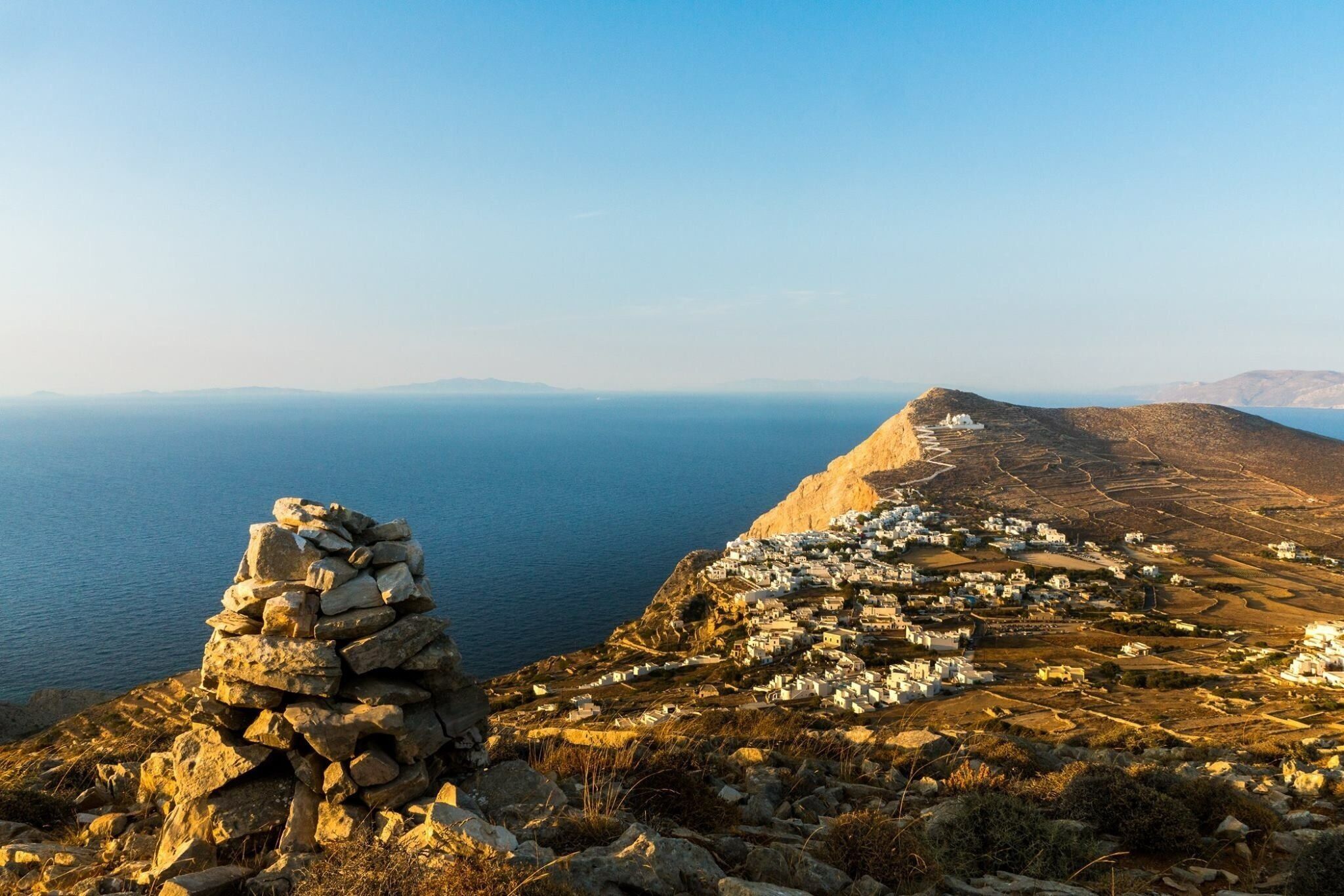 A coastal village with stone structures and a clear view of the sea.