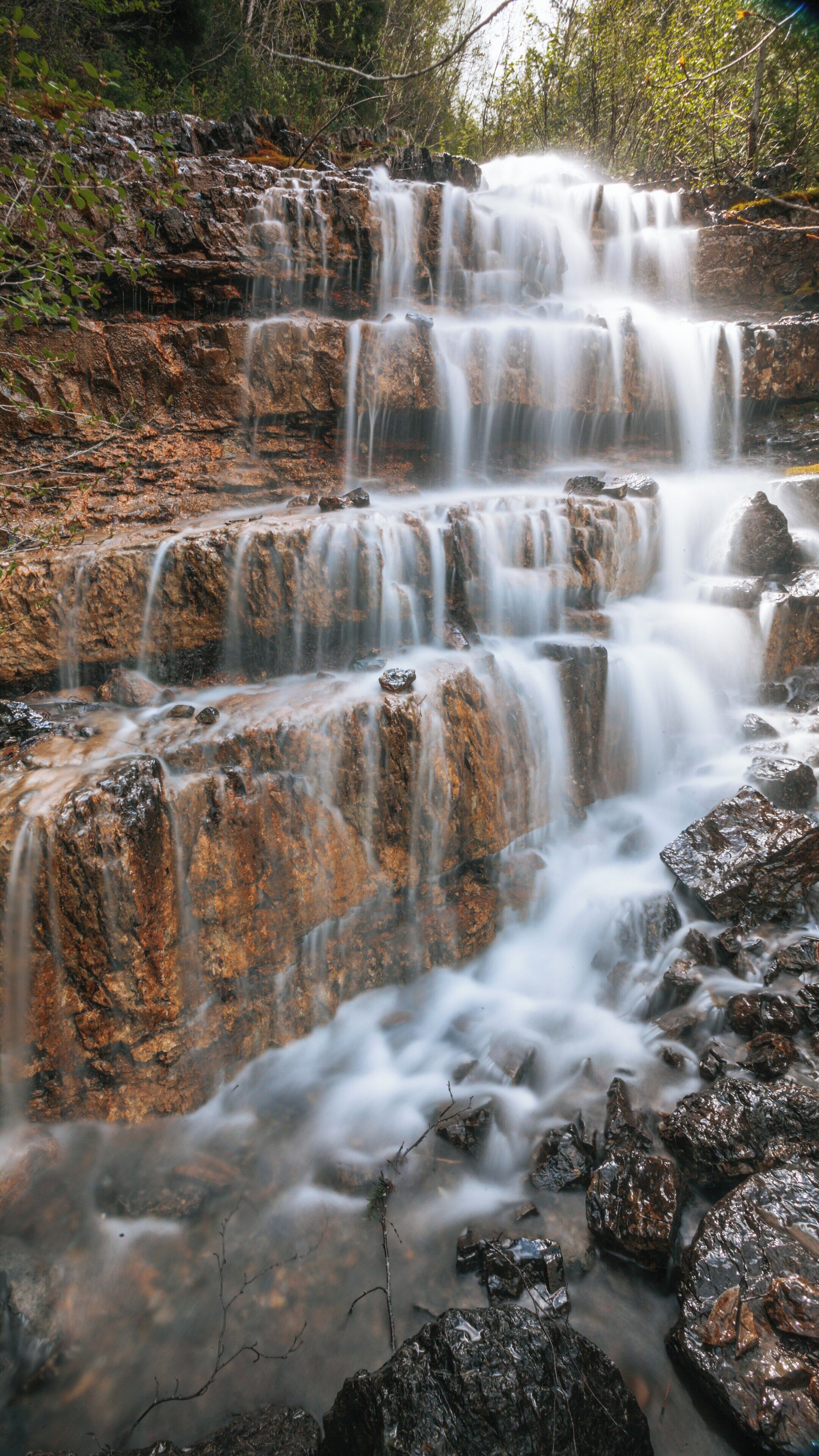 Cascading waterfalls create beauty in Glacier National Park, Kalispell, Montana, showcasing nature's splendor in a serene setting