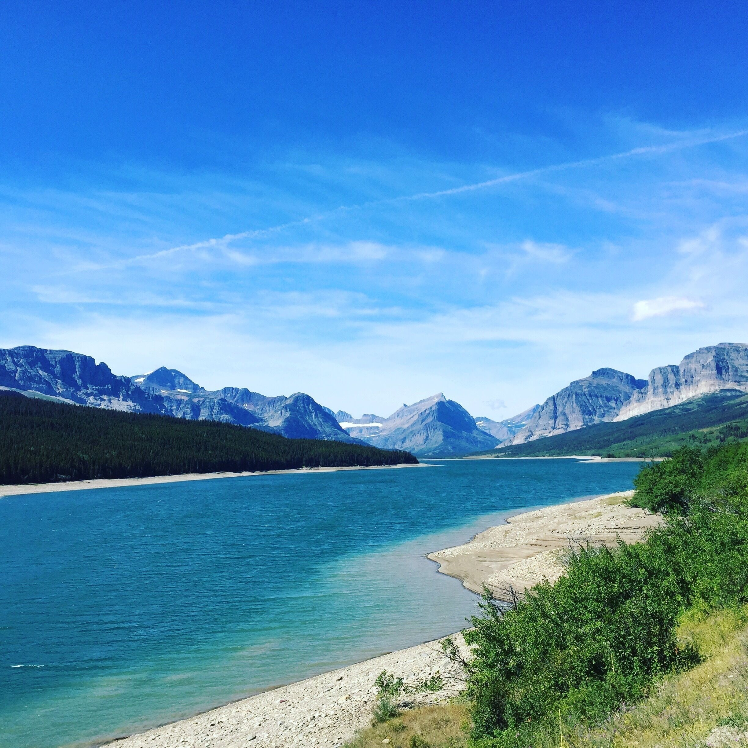 We stumbled upon this amazing view of the mountains and pristine blue water on our way to St. Mary Lake. #mountains #bluewater 