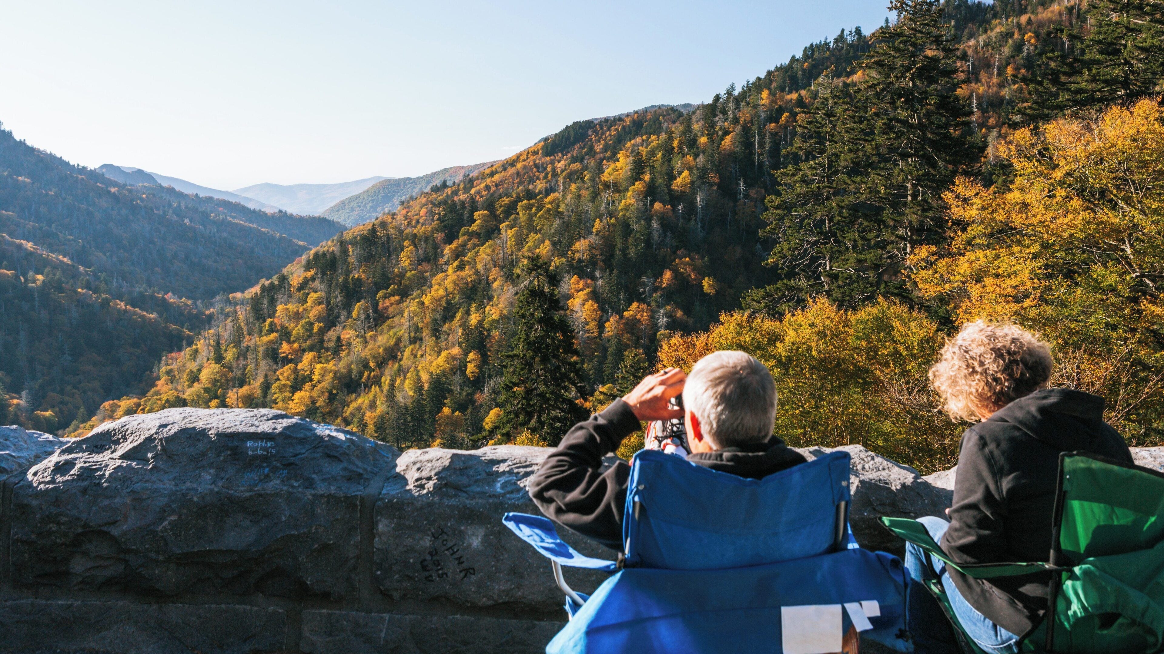 Couple enjoying the autumn view of vibrant foliage in Great Smoky Mountains National Park, Gatlinburg, Tennessee during sunny day