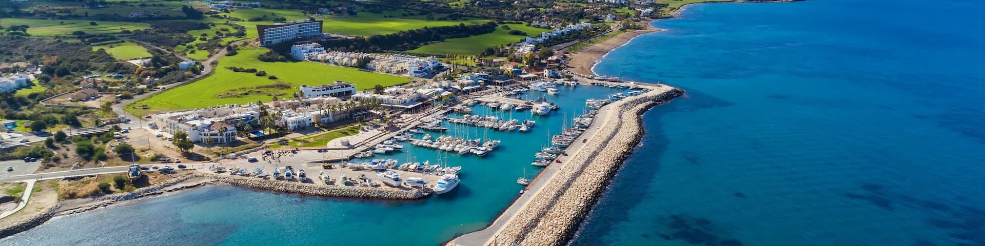 Aerial bird's eye view of Latchi port, Akamas peninsula, Polis Chrysochous, Paphos,Cyprus. Latsi harbour with boats and yachts, fish restaurant, promenade, beach tourist area and mountains from above