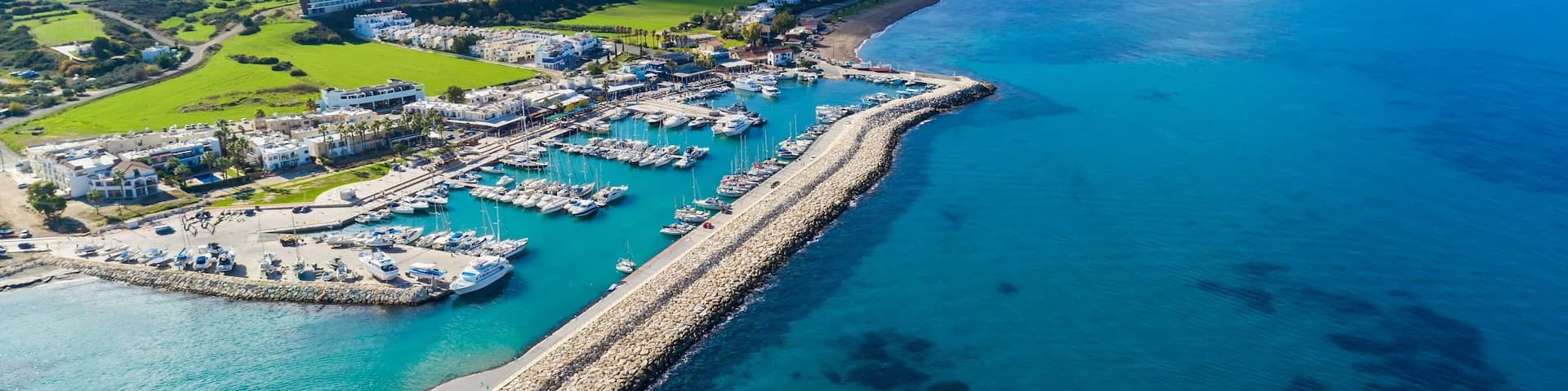 Aerial bird's eye view of Latchi port,Akamas peninsula,Polis Chrysochous,Paphos,Cyprus. The Latsi harbour with boats and yachts, fish restaurant, promenade, beach tourist area and mountains from above