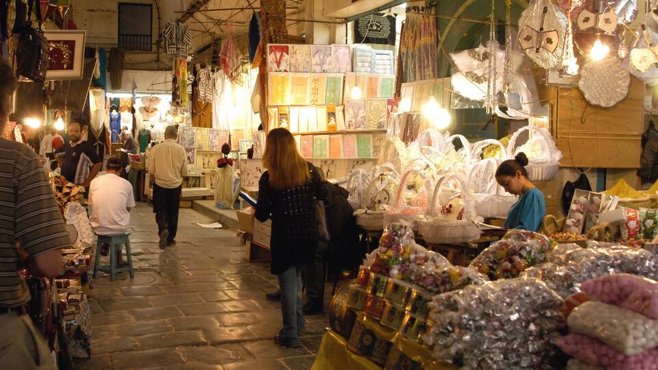 A busy market with stalls selling various items like ceramics, textiles, and jewelry.
