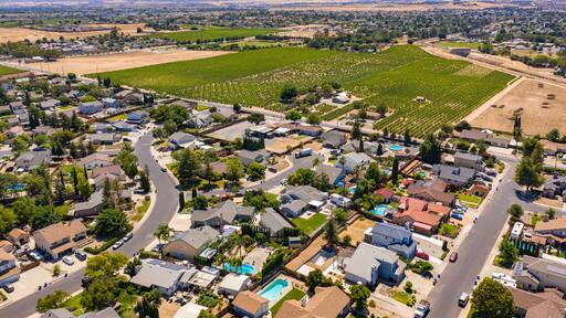 Drone photos over a community in Northern California. With houses, trees and a blue sky