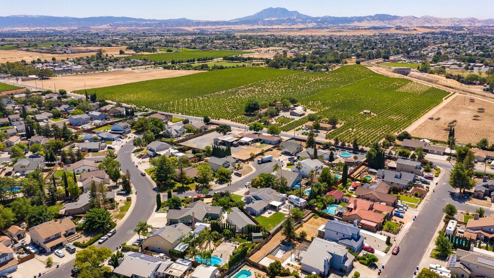 Drone photos over a community in Northern California. With houses, trees and a blue sky
