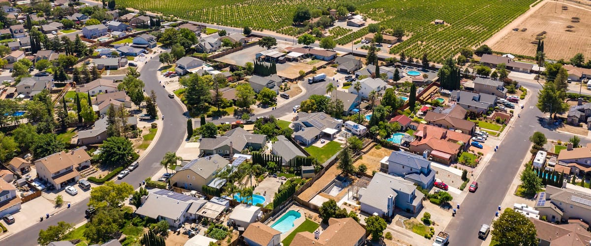 Drone photos over a community in Northern California. With houses, trees and a blue sky