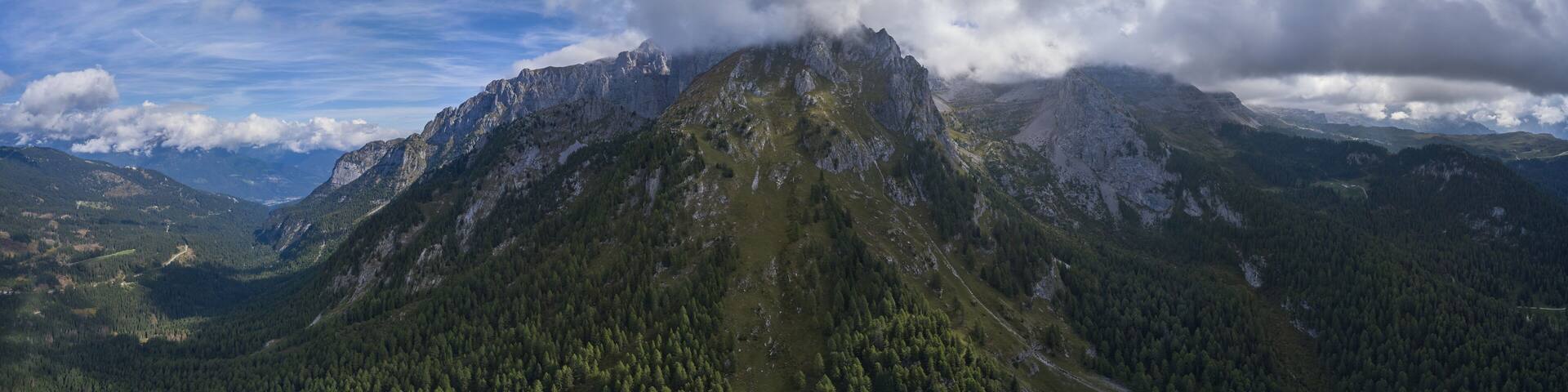 Panorama of the Alps at the foot of Madonna di Campiglio Italy. The high mountain of Cima Tosa has steep rocky slopes at the top for rock climbing and scenic views.