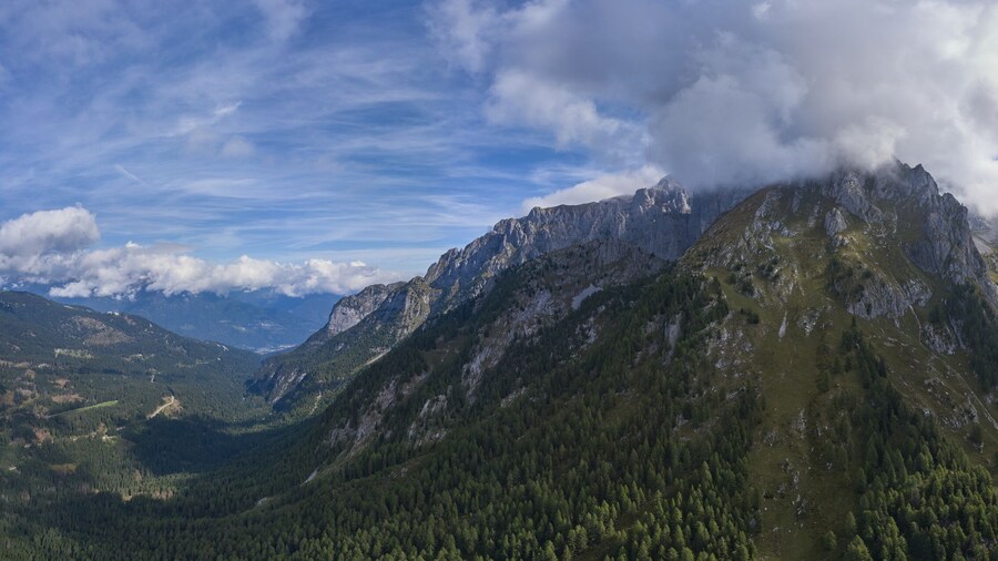 Panorama of the Alps at the foot of Madonna di Campiglio Italy. The high mountain of Cima Tosa has steep rocky slopes at the top for rock climbing and scenic views.