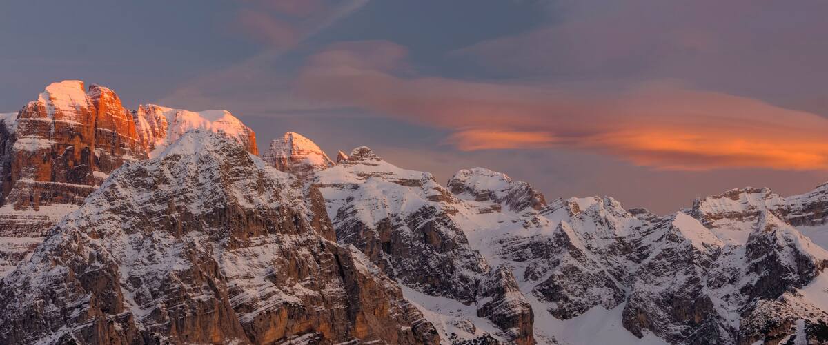 Berglandschap bedekt met sneeuw, met een zonsonderganglucht.