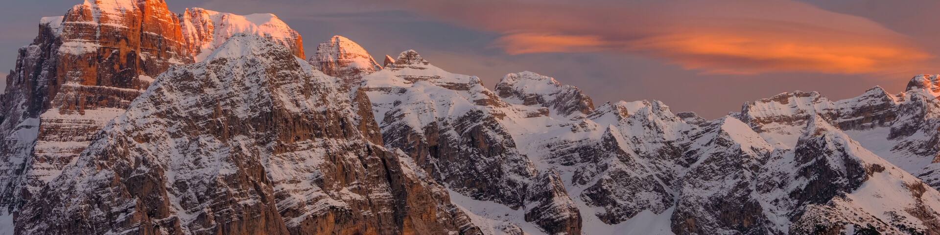 Snow-covered mountains with a sunset sky.