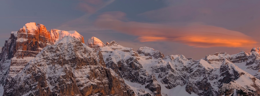 Montañas nevadas con un cielo al atardecer.