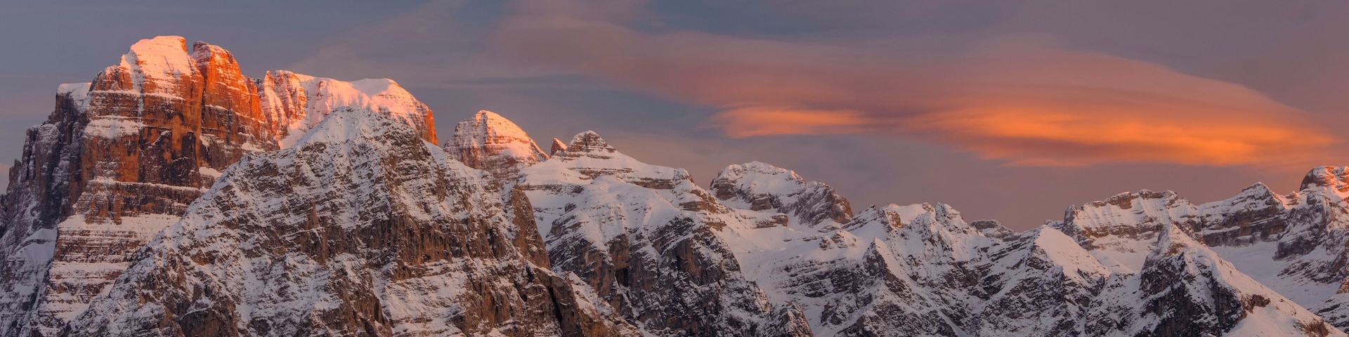 Montañas nevadas con un cielo al atardecer.